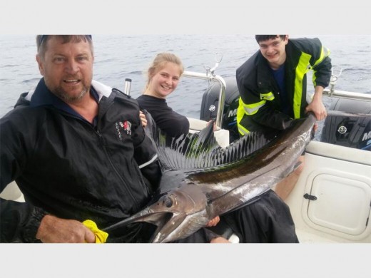 Caught ... and released: Cindy Tapson of Uvongo, who is part of the Ocean Marine Boating team, with the 40kg (plus minus) sailfish she caught on Sea Pro off Protea Reef this week. Helping her hold the fish are her father Colin and boyfriend Rickhert Lubbe. PHOTO BY NADINE TAPSON