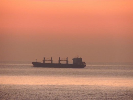 Red skies in the morning and a ship glides past Orange Rocks.