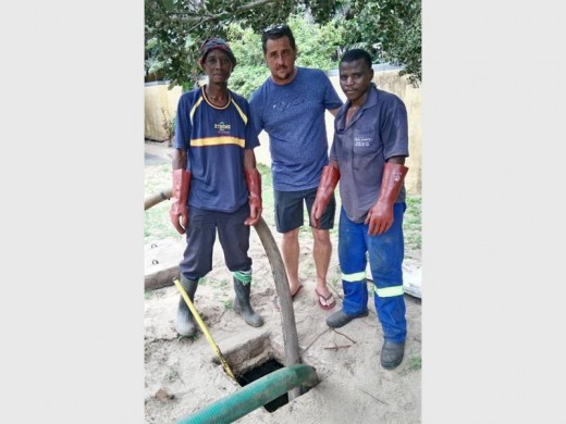 Saving the day: Mongezi Zulu and Simnikoi Qina of Drain Experts and Councillor Leon Gabarde empty the septic tanks at Tweni Beach.