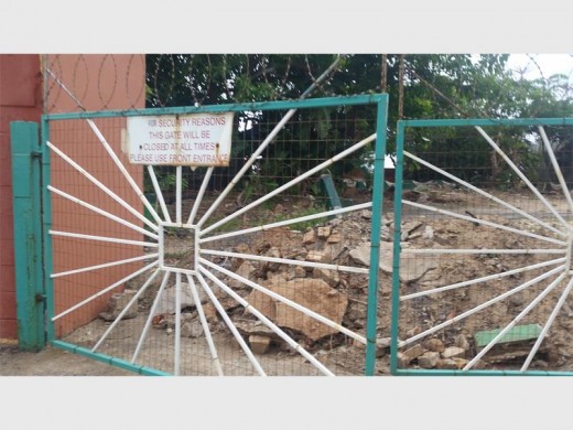 Derelict: The gates of the abandoned amusement park stand open.