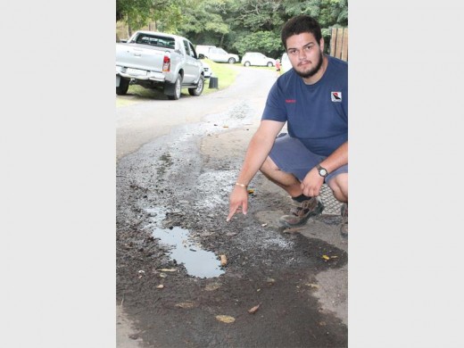 Problematic: Henco Mare, Hennie's son points to the 'blackwater' running down the road towards the Uvongo river.