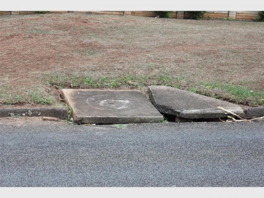 A broken drain cover in Norman Tedder Road