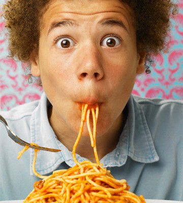 Teenage Boy Slurping Spaghetti Bolognaise --- Image by © Steve Lupton/Corbis