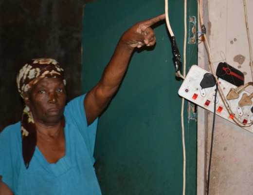 Gogo MaMthembu Mlungwana, one of the RDP house applicants who never received her house, points at a dangerous and poorly assembled electrical connection in her single room house PHOTOS: Steven Makhanya
