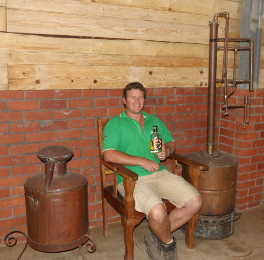 Greg sits next to the prototype still he built while developing Tapanga Rum