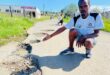 Esithombeni uLwazi Mncwabe ekhomba indlela umgwaqo wabo ongekho ngayo esimweni esigculisayo. Isithombe: MOEKETSI MAMANE