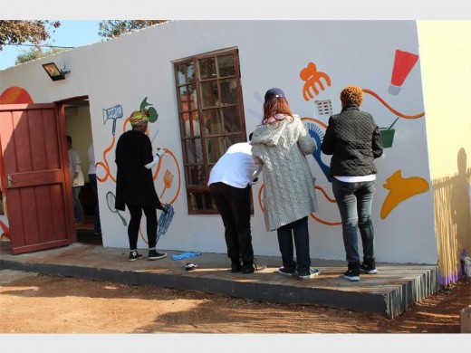 Some of the staff paint a mural and set up a hair salon.