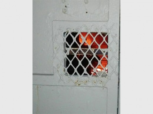 Flames can be seen through one of the house gates.