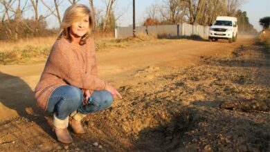 Belynda Nauschutz points at a huge hole on untarred Austin Road in Glen Austin, Midrand. Photo: Sphiwe Masilela