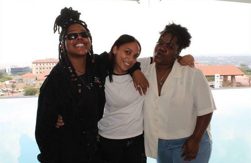 Yolanda Kalunga, Christine Brigham and Florence Kalungu embrace each other.