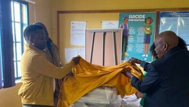 School faculty and Alex Songo, deputy chief and education specialist, open the new printer