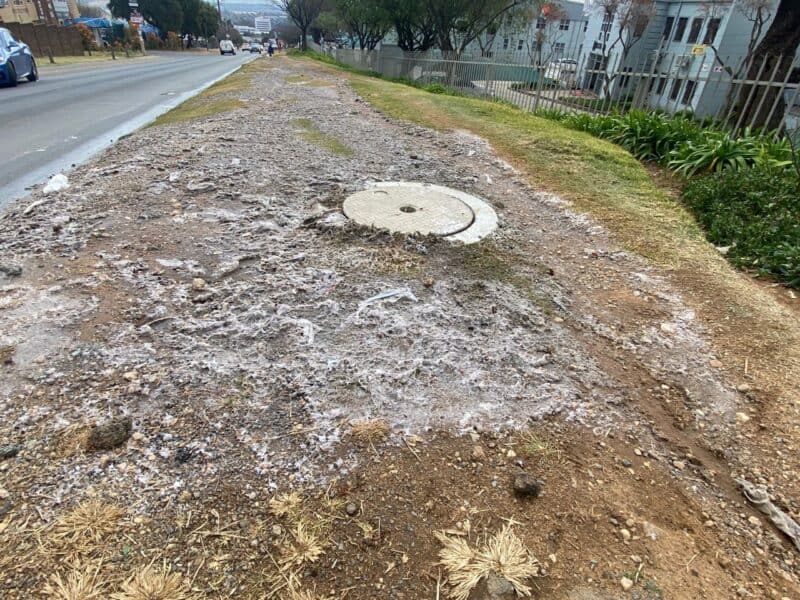One manhole appears to be fixed while another one continues to flood Richards Drive with dirty water.