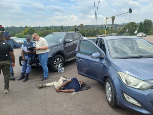 A suspect is arrested next to their getaway blue Hyundai i20. Photo: Supplied