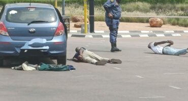 Police watch over the two arrested suspects after a shootout on Allandale Road, Midrand. Photo: Supplied