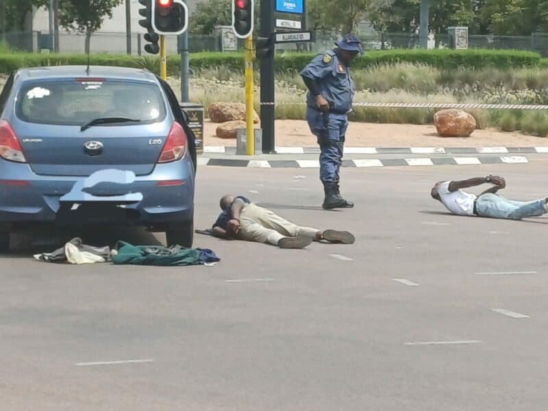 Police watch over the two arrested suspects after a shootout on Allandale Road, Midrand. Photo: Supplied