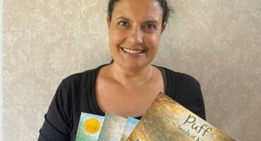 Carla De Gouveia poses for a picture with four of her released books. Photo: Supplied