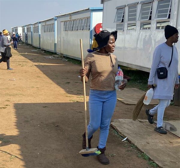 Parents arrive with brooms and cleaning supplies for the volunteer clean-up campaign on May 30, 2026. Photo: Comfort Makhanya.