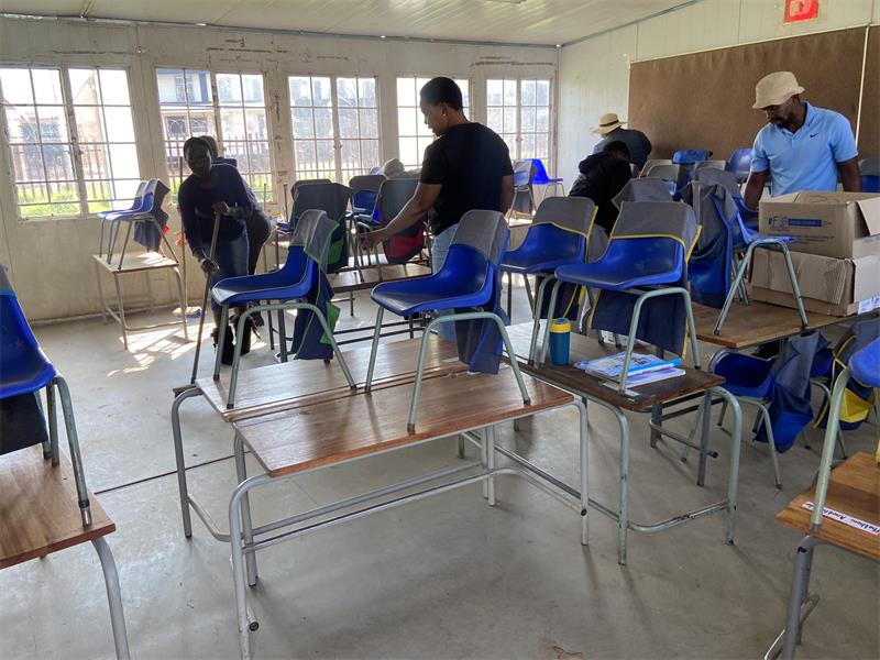Parents arrive with brooms and cleaning supplies for the volunteer clean-up campaign on May 30, 2026. Photo: Comfort Makhanya.