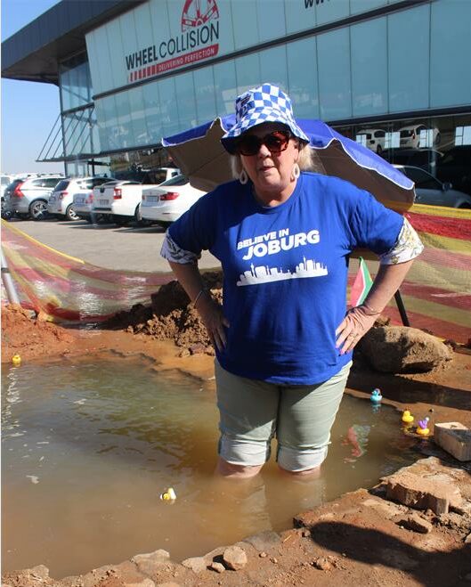Ward 132 councillor Annette Deppe stands in pooled water caused by a leak that has reportedly remained unresolved for 14 days despite being reported to Joburg Water on May 28. Photo: Comfort Makhanya