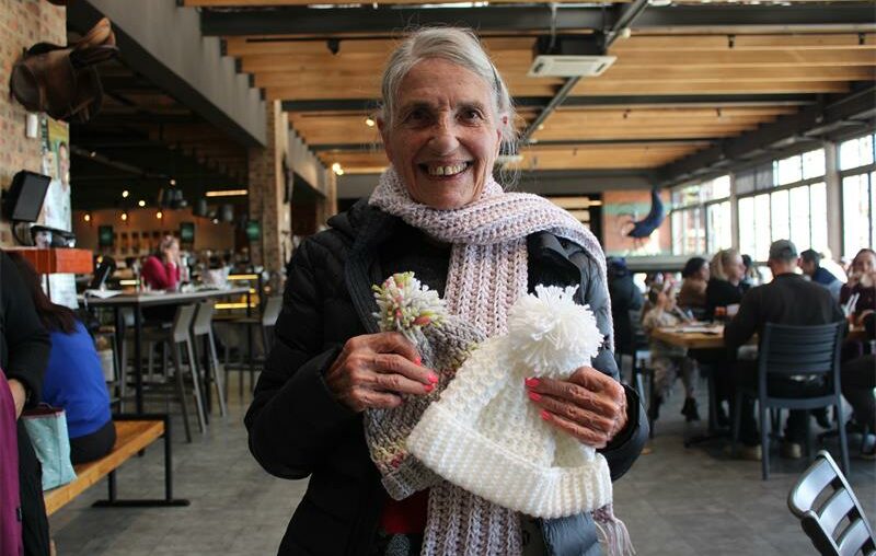One of the members of Knit and Natter, Olive Ravenall, holds some of the items she knitted for the day. Photo: Zanele Mfaba