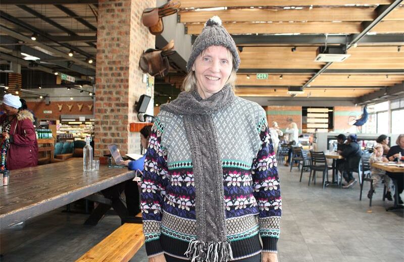 Another Knit and Natter member, Carol Barnes, wears a beanie and scarf she made to show how it looks after completion. Photo: Zanele Mfaba