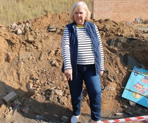 Ward 132 councillor Annette Deppe stands inside the dug up hole and incomplete storm water repair on Maple Drive. Photo: Zanele Mfaba