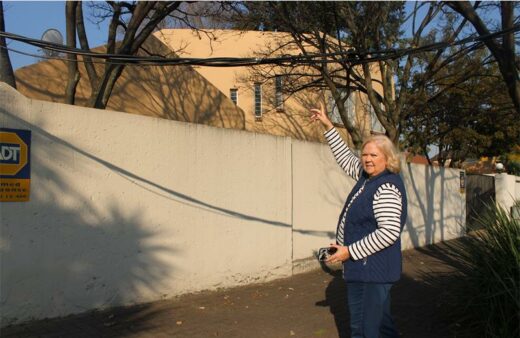Councillor Annette Deppe standing under a hanging cable at one of the houses in Halfway Gardens Ext 4. Photo: Zanele Mfaba