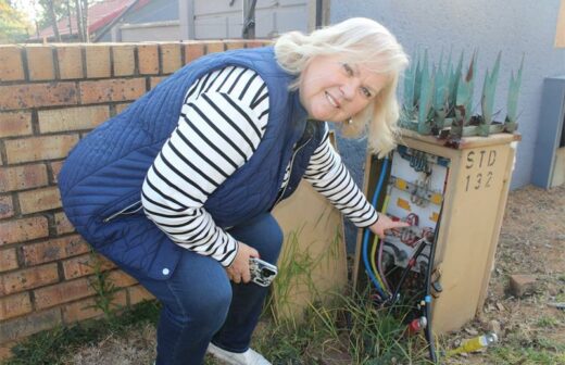 Ward 132 Councillor Annette Deppe next to one of the left-open power boxes on Neerlandia Road. Photo: Zanele Mfaba