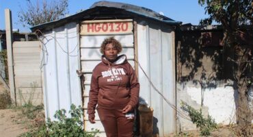 Annikie Mothibi stands next to the zozo structure she alleges was moved from her original stand to another section of the Harry Gwala informal settlement while she was recovering in hospital on July 2, 2026. Photo: Comfort Makhanya