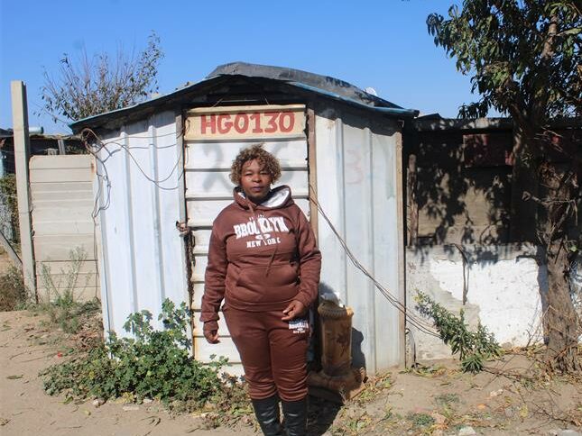 Annikie Mothibi stands next to the zozo structure she alleges was moved from her original stand to another section of the Harry Gwala informal settlement while she was recovering in hospital on July 2, 2026. Photo: Comfort Makhanya