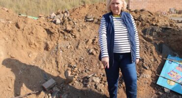 Ward 132 Cllr. Annette Deppe stands inside the dug-up hole and incomplete stormwater repair on Maple Drive on June 26. Photo: Zanele Mfaba