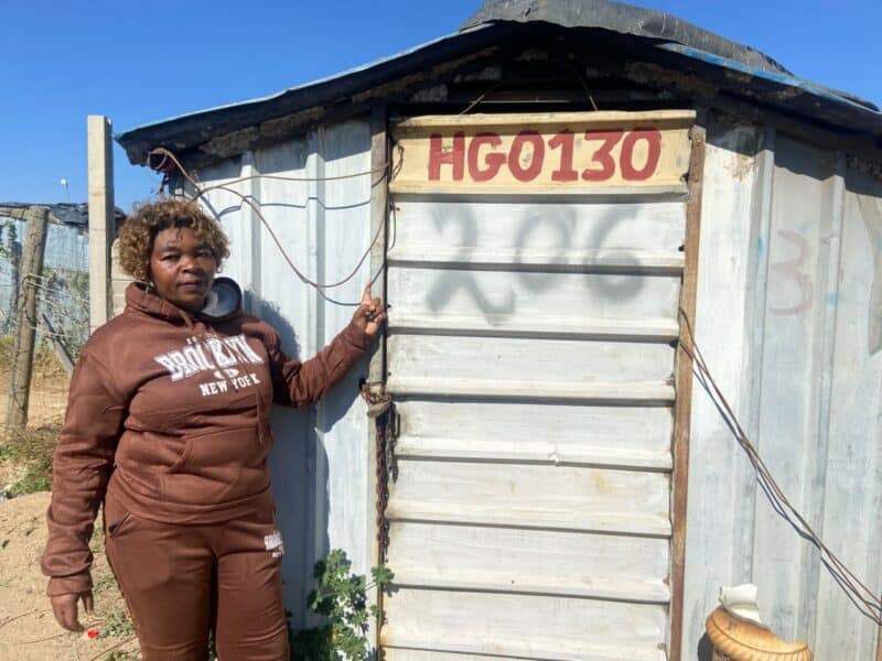 Annikie Mothibi stands next to the zozo structure she alleges was moved from her original stand to another section of the Harry Gwala informal settlement while she was recovering in hospital on July 2. Photo: Comfort Makhanya
