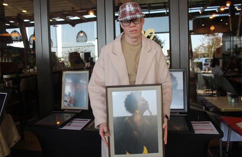 Artist Angelo Veyi holds his Afrocentric tale artwork at the Tell Your Story Through Art silent auction. Photo: Zanele Mfaba