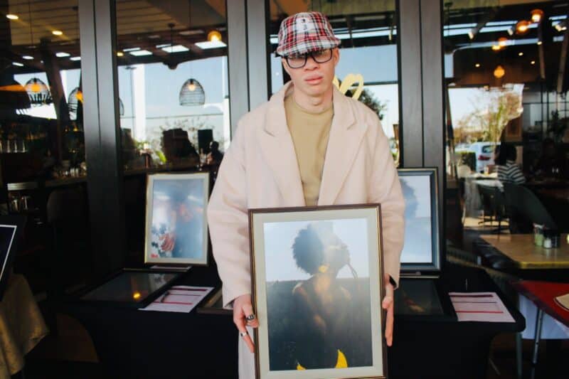 Artist Angelo Veyi holds his Afrocentric tale artwork at the Tell your story through art silent auction on August 2, 2026. Photo: Zanele Mfaba