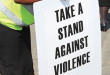 Image of a person holding an anti GBV poster.