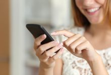 Image of a human hand holding a cellphone.