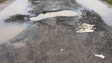 Image of a badly potholed road in Dundee filled with water.