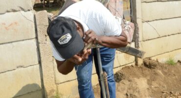 Image of a person trying to drink water from a communal tap, Dundee.