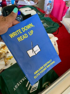 An educator holdsthe The 'Write Down, Read Up' book written by young wrtiers from different school across the Amajuba District.