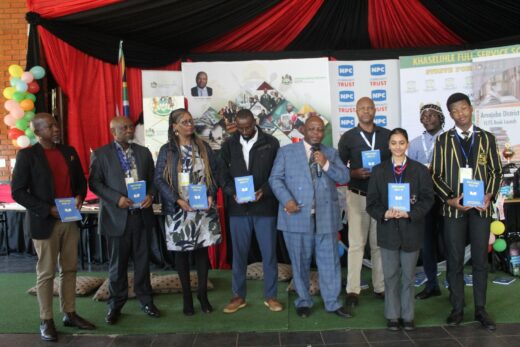Department of Education officials with the students holding the collaborative book.