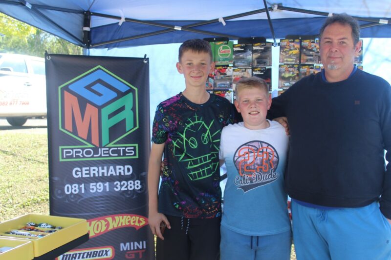 Gerhard, Janco and Lehan standing at the MGR Projects stall during the Grace Park Market Day.