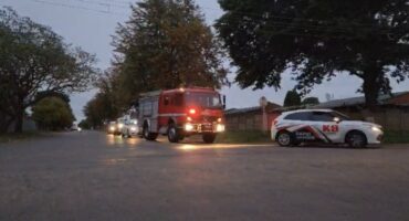 Image of a security car with a fire truck with its lights on following in convoy, followed by other cars.