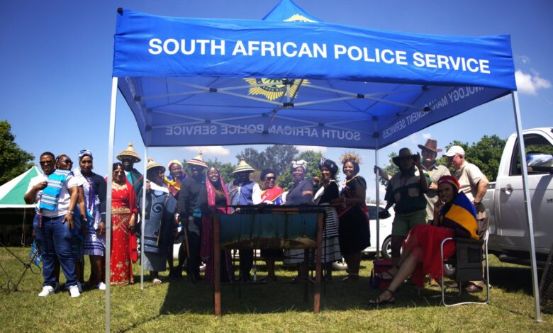 Amajuba District SAPS members dressed in traditional attire stand under a South African Police Service tent during Heritage Day celebrations.
