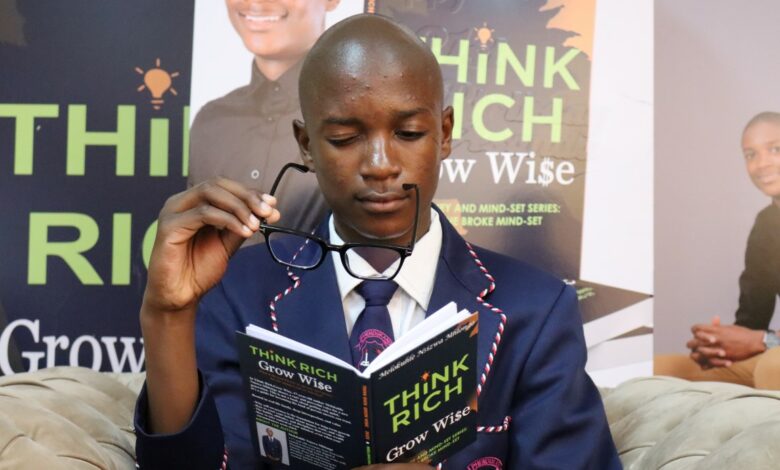 A 17-year-old student in a school uniform reads his debut book Think Rich Grow Wise during its launch at Newcastle Library.