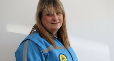 Belinda Ellor, Newcastle Community Policing Forum Deputy Chairperson, wearing a blue CPF jacket, standing against a white wall.