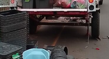 Image of a trailer with flat tyres and items like plastic buckets and containers that a trader was selling.