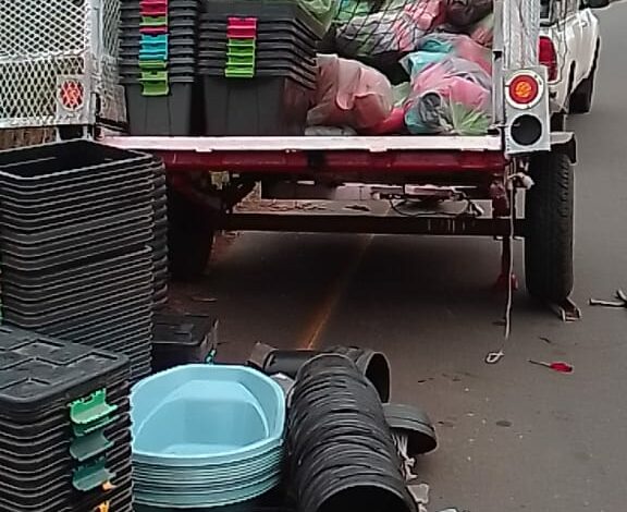 Image of a trailer with flat tyres and items like plastic buckets and containers that a trader was selling.