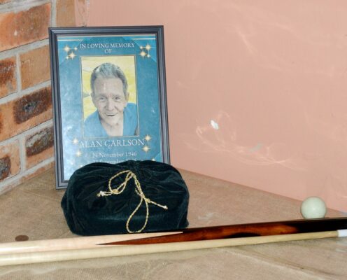 Image of a photo of a late pool player with cue.