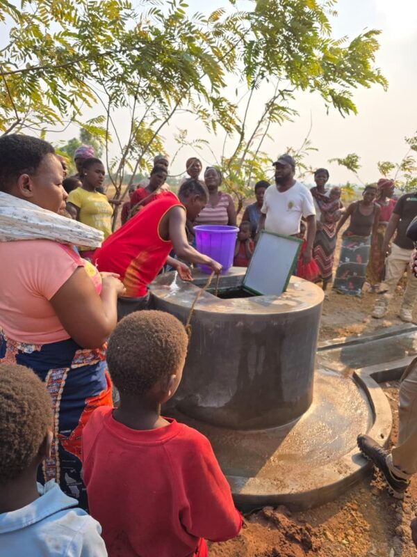 Malawi locals getting water from a newly built water well.