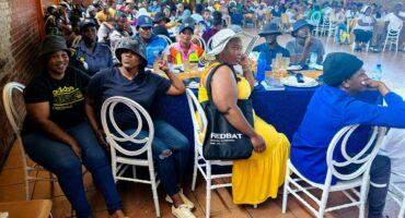 Image of mainly women seated at tables in hall at a crime awarness workshop in Glencoe. Photo: Umzinyathi SAPS.